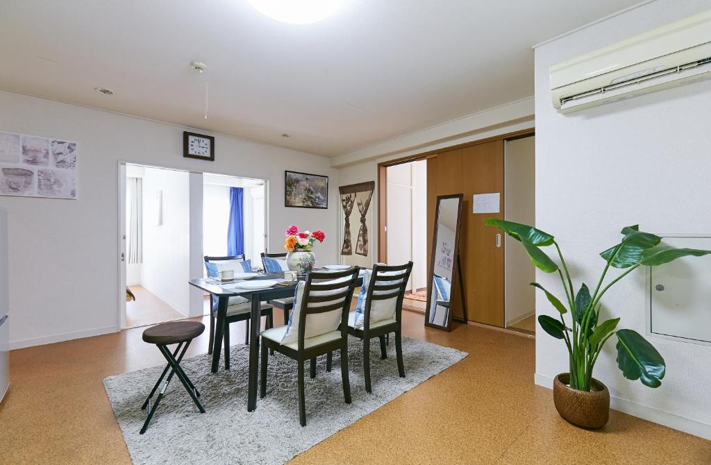 een eetkamer en een woonkamer met een tafel en stoelen bij Haneda Lex House in Tokyo