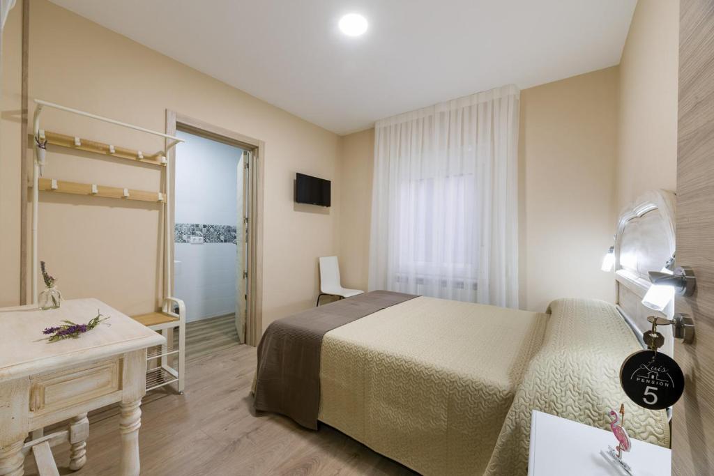 A bed or beds in a room at Pensión Luis