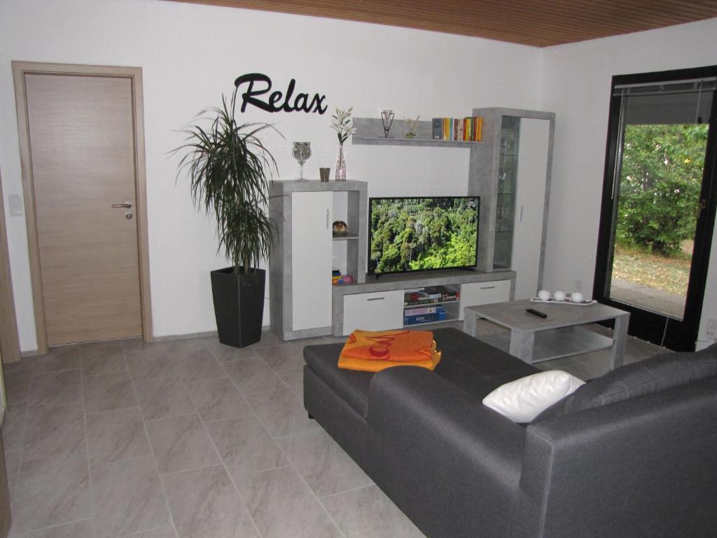 sala de estar con sofá y TV de pantalla plana en Ferienwohnung Seligenporten, en Seligenporten