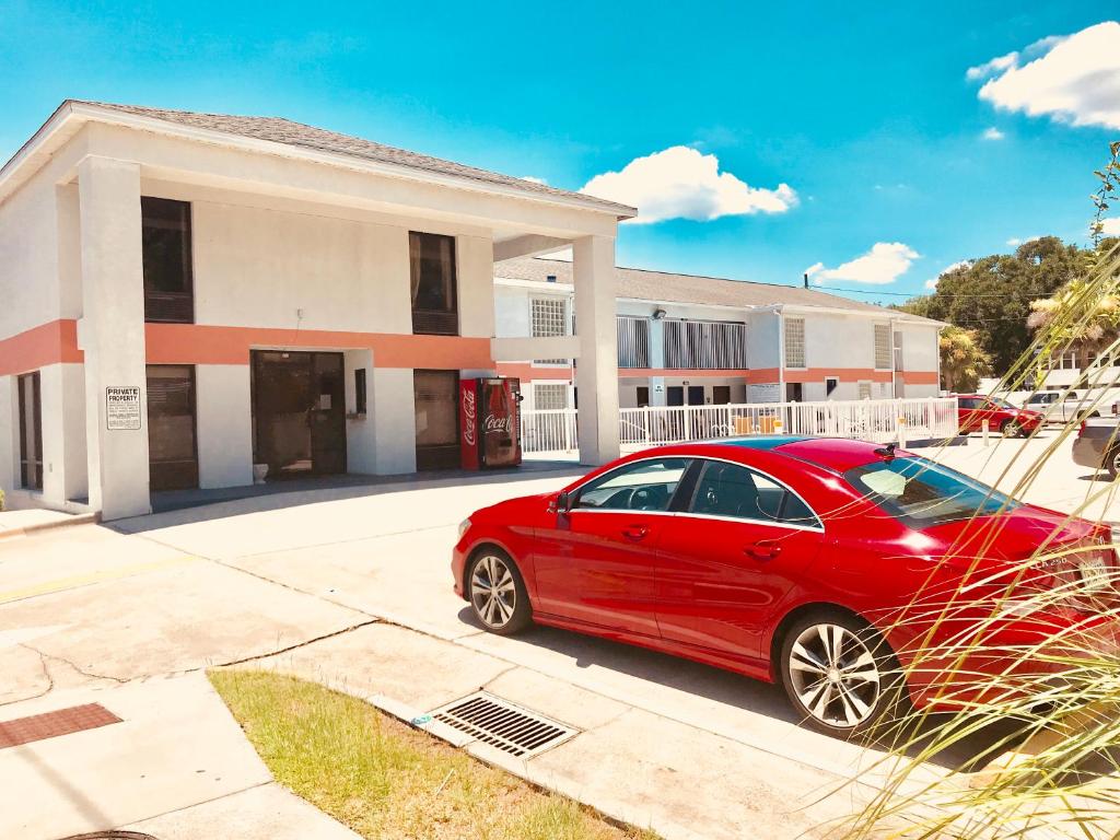una macchina rossa parcheggiata di fronte a una casa di Sky Suites a Tybee Island