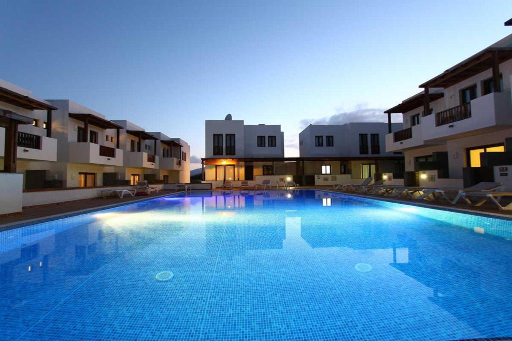 a large swimming pool in front of some buildings at Casa Zen in Puerto Calero