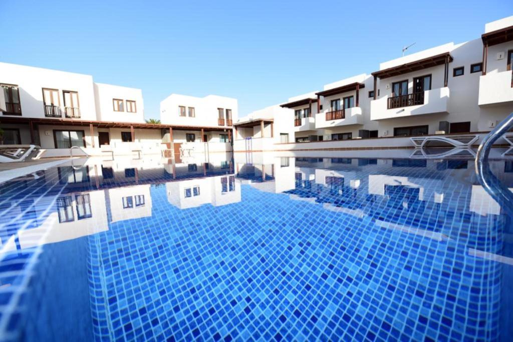 a swimming pool in front of some buildings at Casa Zen in Puerto Calero