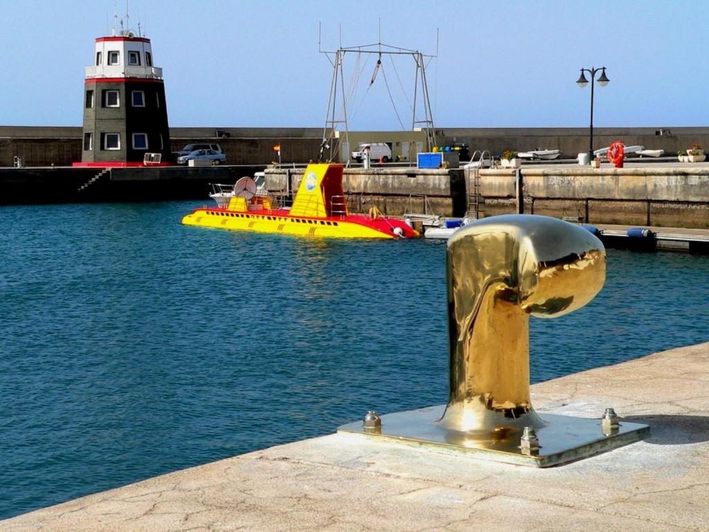 a gold hydrant in a body of water with a boat at Casa Zen in Puerto Calero