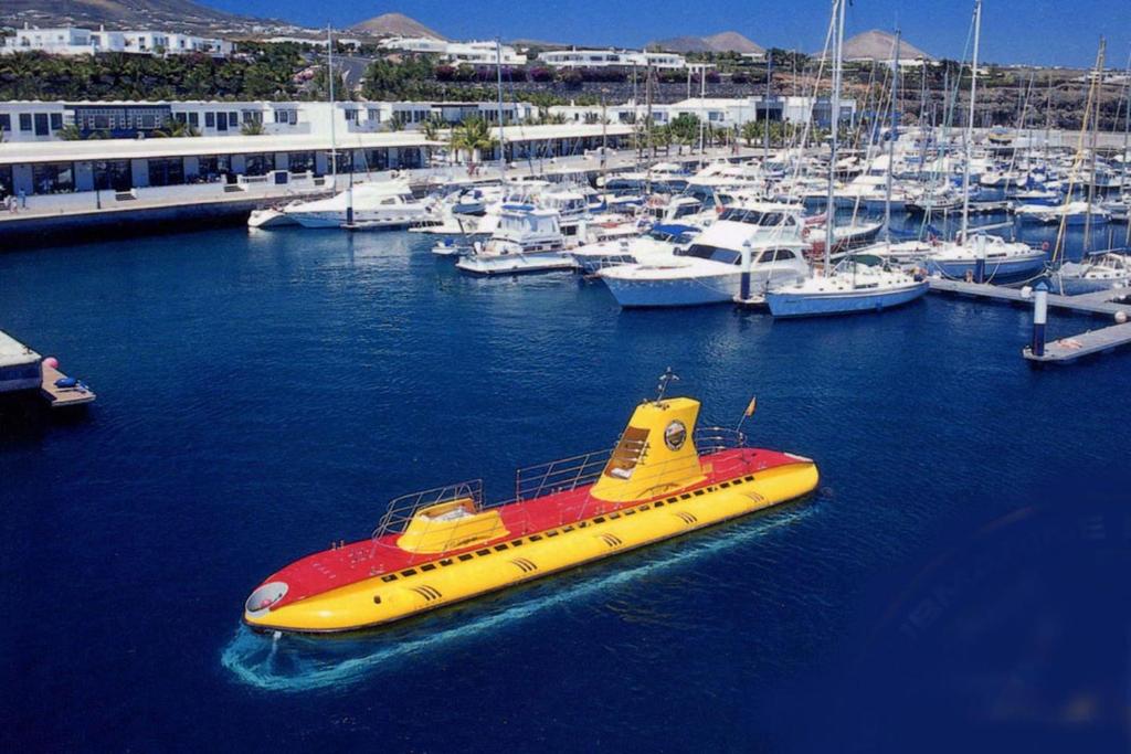 a yellow and red boat in a marina with boats at Casa Zen in Puerto Calero