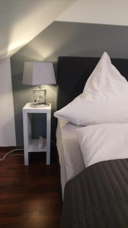 um quarto com uma cama e uma mesa de cabeceira com um candeeiro em Ferienwohnung mit 2 Schlafzimmern und Parkplatz em Erfurt