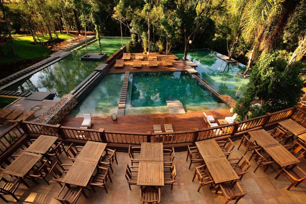 een uitzicht op een zwembad met stoelen en een terras bij Loi Suites Iguazu Hotel in Puerto Iguazú
