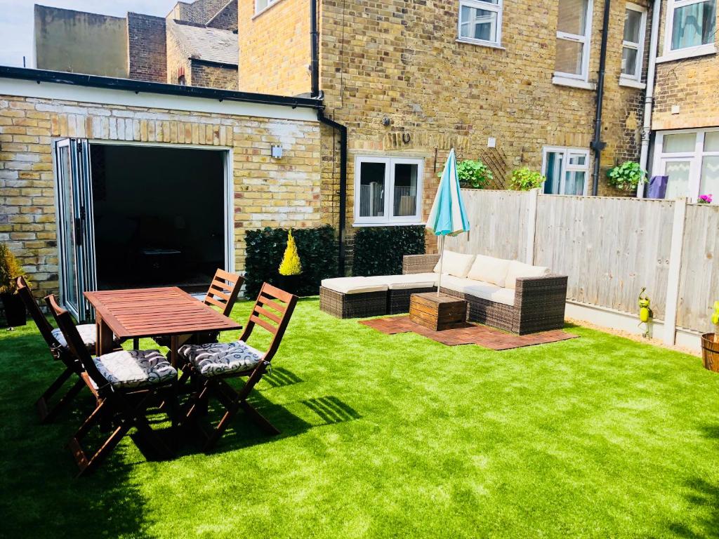 a backyard with a table and chairs and a couch at Garden Oasis in Margate