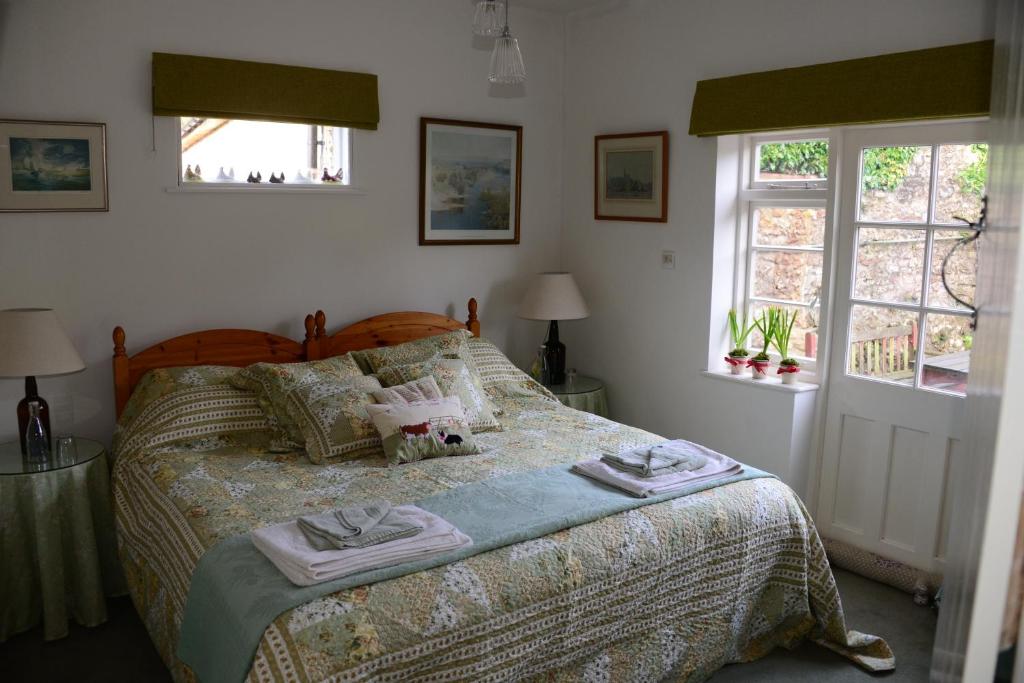 a bedroom with a bed with two towels on it at Middle Farm Cottage in Wells
