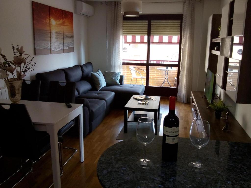 een woonkamer met een fles wijn en 2 wijnglazen bij Estudio Bellavista in Logroño