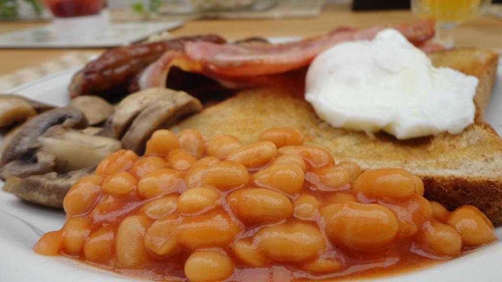a plate of breakfast food with eggs bacon mushrooms and toast at ASURE Destiny on Fitzherbert Motel in Palmerston North