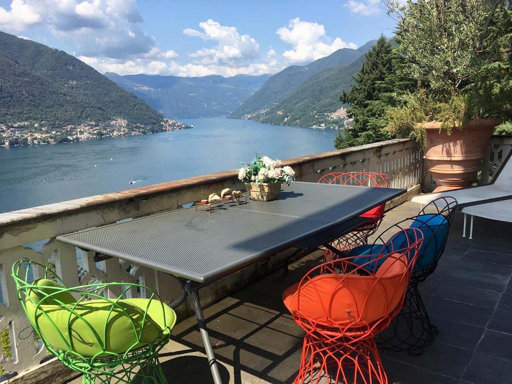 stół i krzesła na balkonie z widokiem na jezioro w obiekcie Lake Como Villa Ines Apartment w mieście Faggeto Lario 