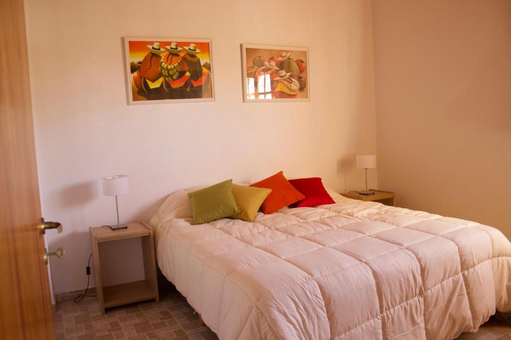 a bedroom with a bed and two pictures on the wall at Apartamento Lencinas in San Rafael