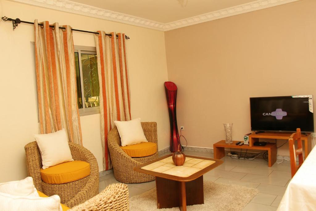 a living room with two chairs and a television at Princess Endale Residence in Douala