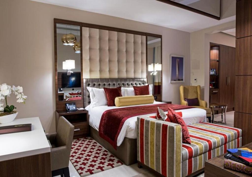 um quarto de hotel com uma cama grande e uma secretária em The Envoy Hotel Abuja em Abuja