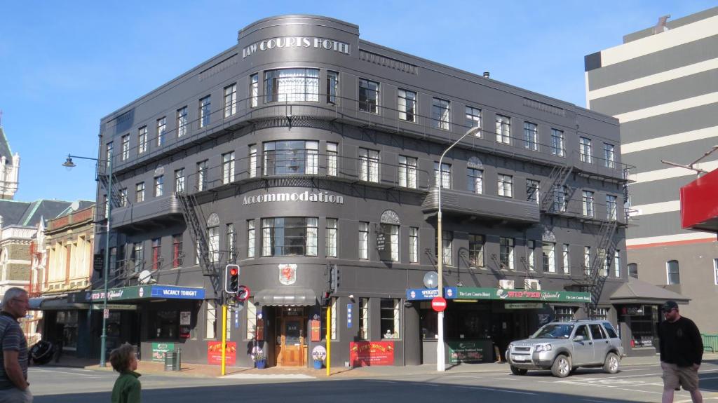 a large gray building on a city street with a traffic light at Law Courts Hotel in Dunedin
