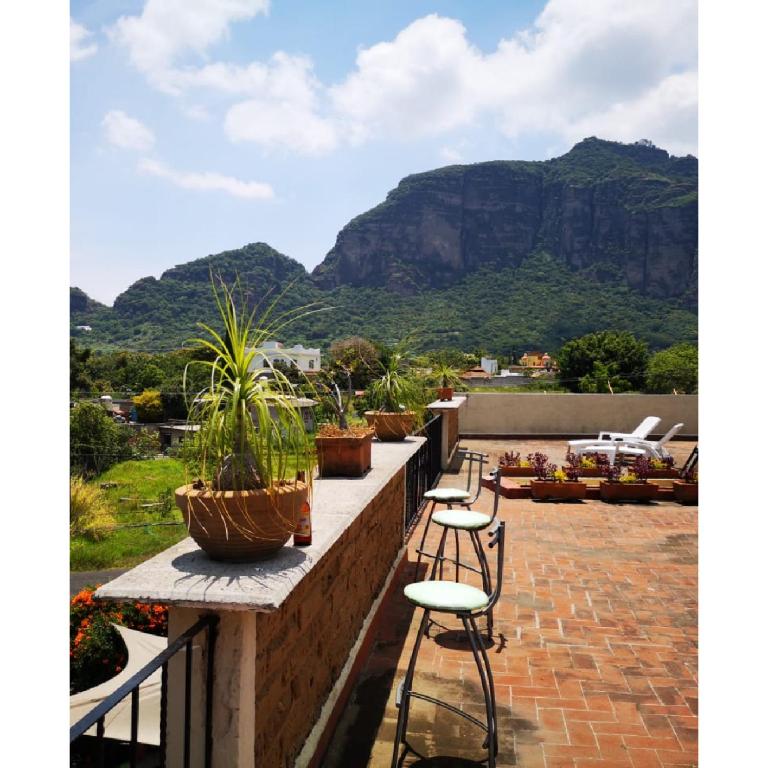 a balcony with chairs and potted plants and a mountain at La Casa del Volcan in Tlayacapan