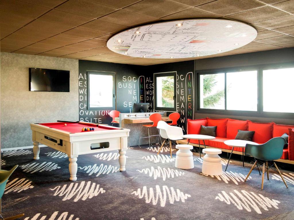 a room with a red pool table and chairs at ibis Avranches Mont St Michel in Saint-Quentin-sur-le-Homme