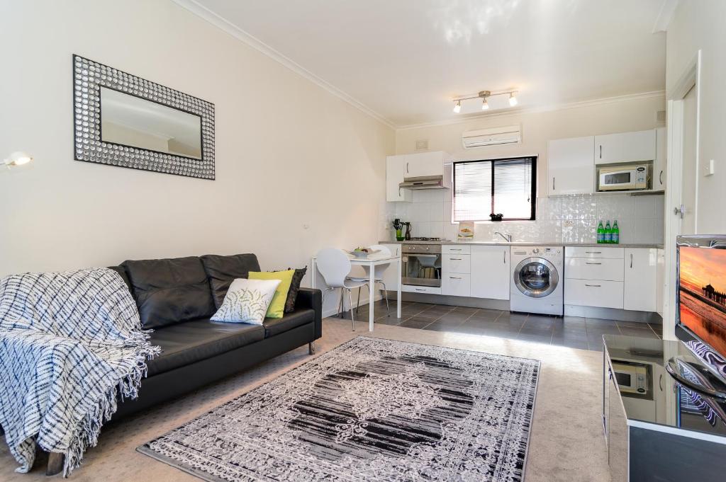 un soggiorno con divano e una cucina di Stylish North Adelaide Apartments a Adelaide