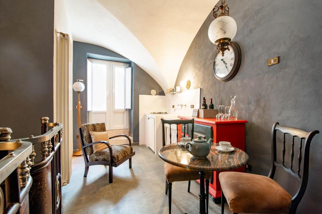 a room with a table and chairs and a kitchen at Portineria 26 in Martina Franca