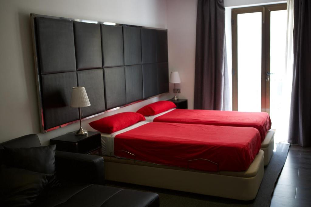 1 dormitorio con cama roja y cabecero grande en Concept Suites, en Alicante