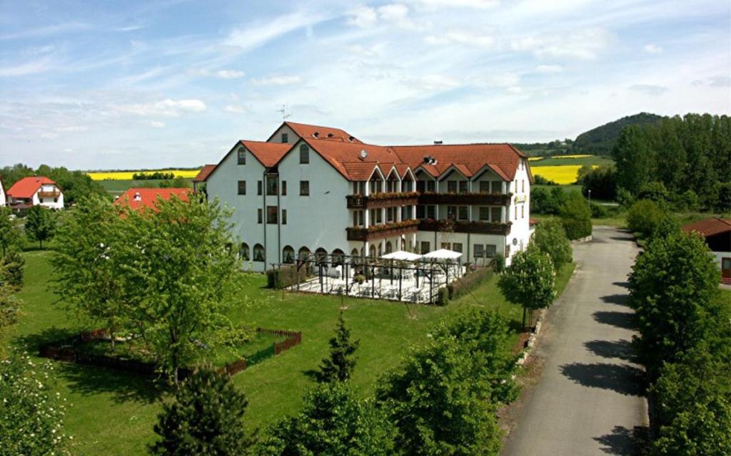 una vista aérea de una gran casa blanca con una carretera en Hotel Restaurant Goger, en Hassfurt