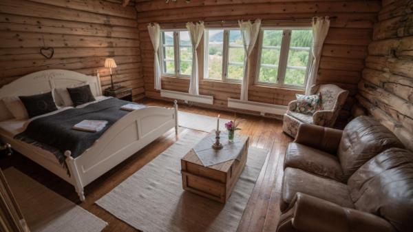 1 dormitorio con 1 cama y 1 sofá en una cabaña de madera en Phillipshaugen Lodge en Øksendalsøra