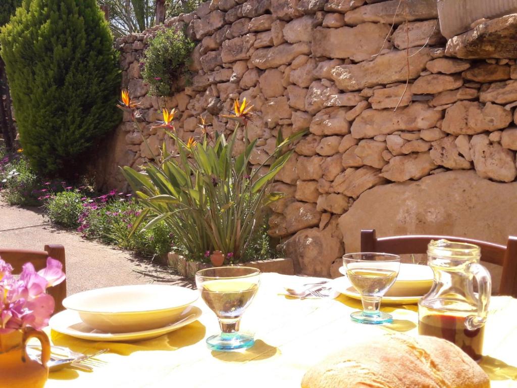 einen Tisch mit einem weißen Tischtuch und Gläsern darauf in der Unterkunft Casa vacanze nel verde del Sinis in San Vero Milis