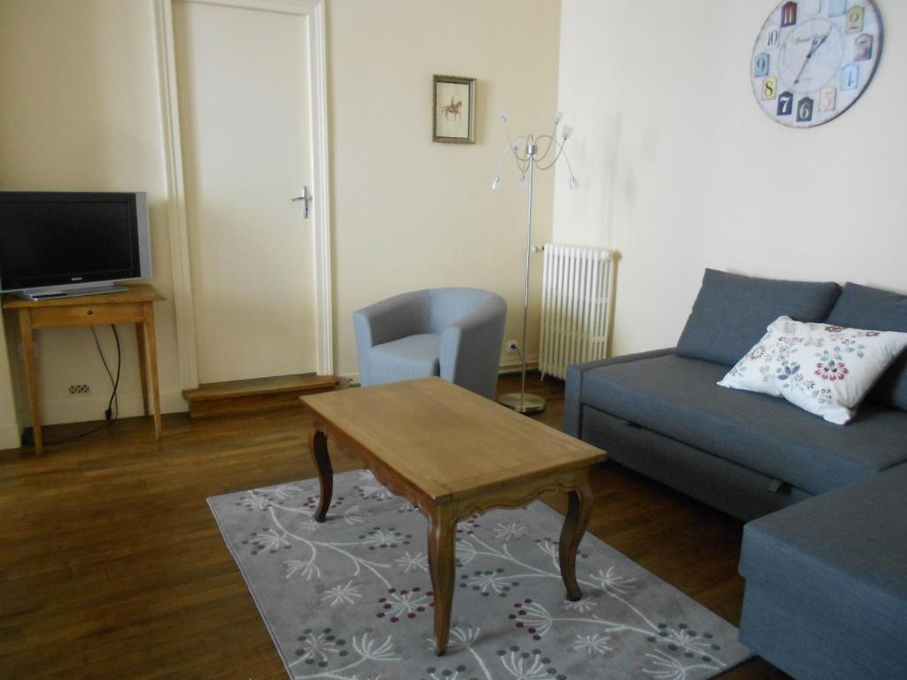 een woonkamer met een bank en een tafel bij 8 Rue de la Petite Bilange " Maison du Centre" in Saumur