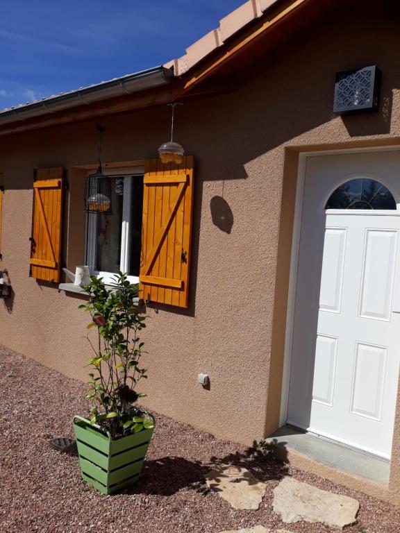 a house with a white door and a potted plant at Chez isa in Massilly