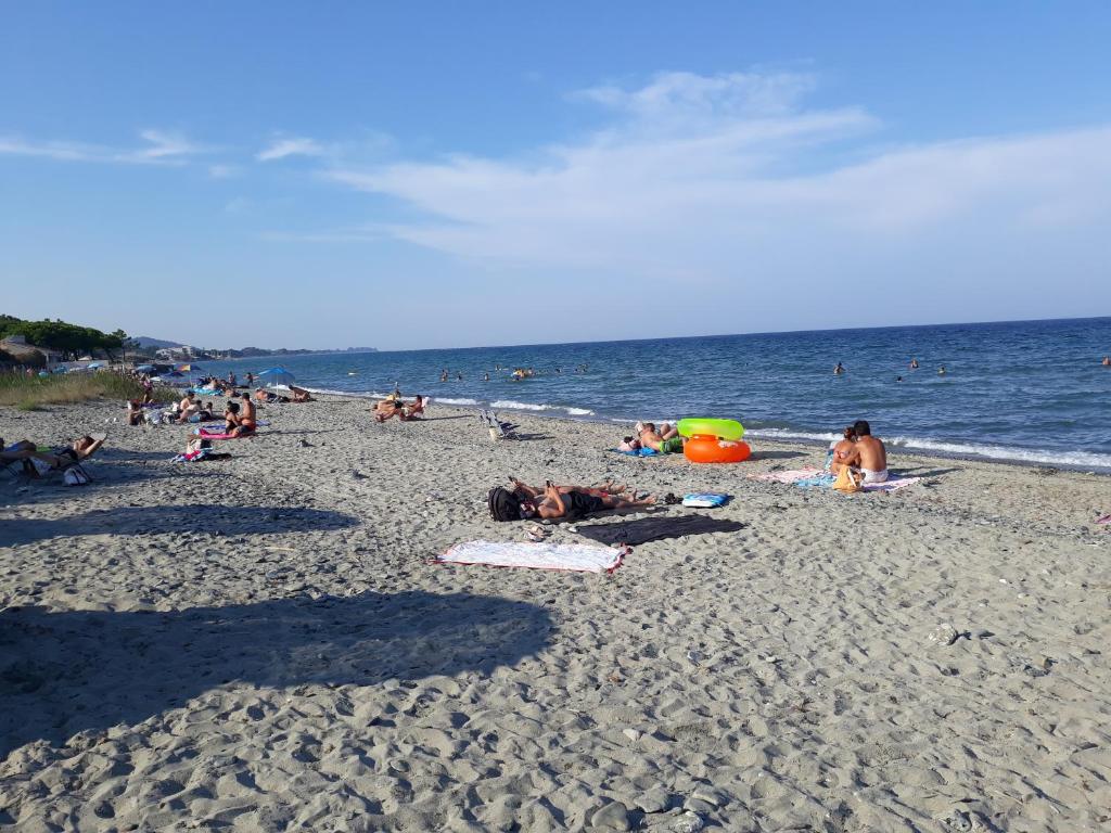 モリアニ・プラージュにあるles pieds dans l'eau les Marines de Moriani 5 couchagesの浜辺に横たわる人々