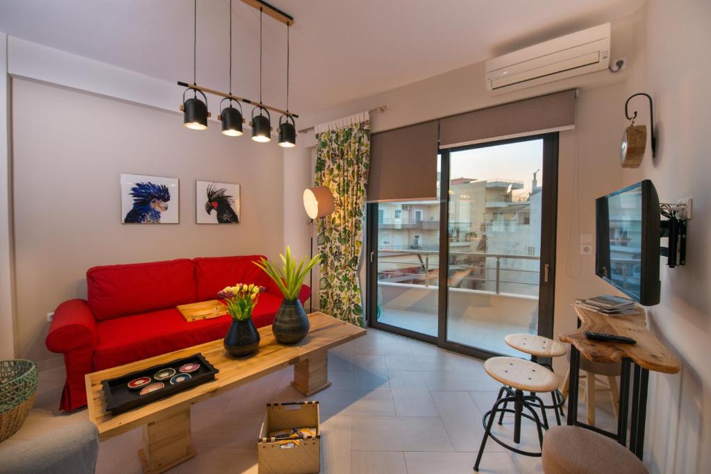 プレベザにあるMarios Home, a cozy and spacious apartment near downtownのリビングルーム(赤いソファ、テーブル付)