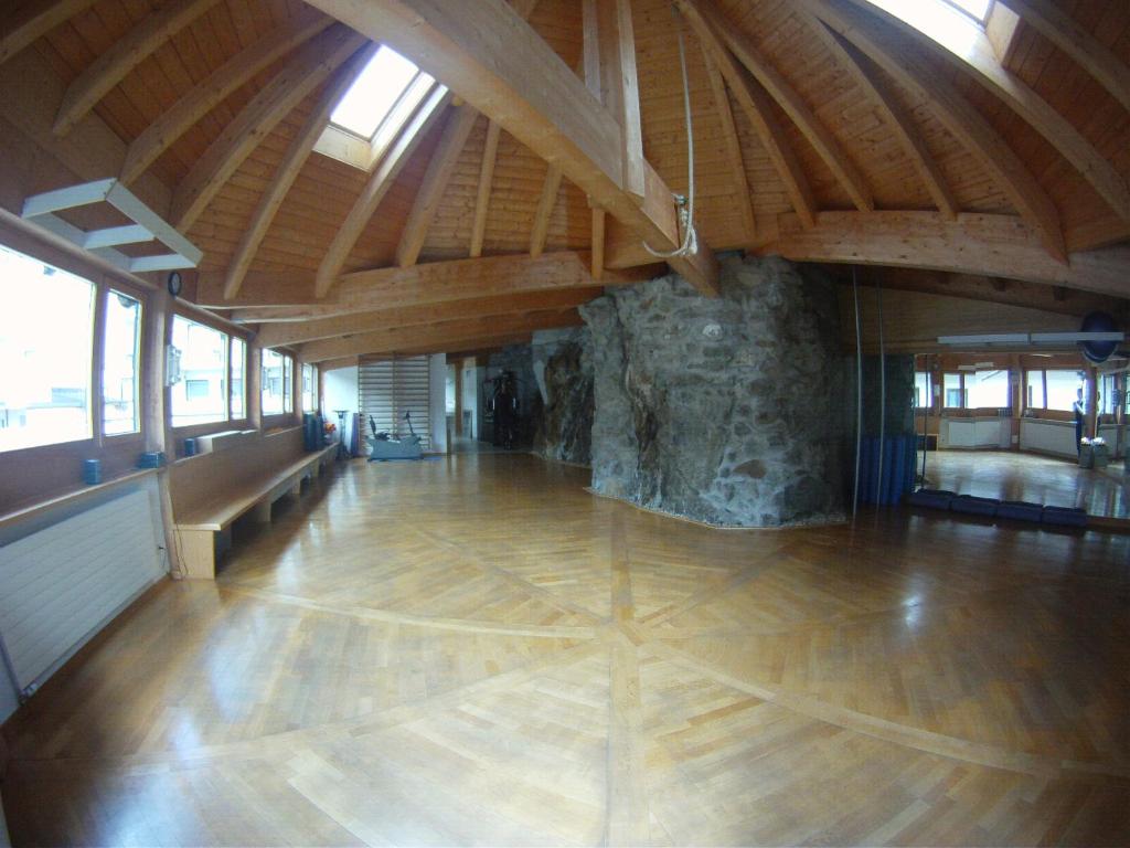 a large room with a wooden floor and a stone wall at Hotel Bären in St. Moritz