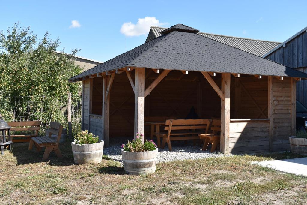 a wooden gazebo with a bench in a yard at Apfelhof Biesenbrow in Biesenbrow