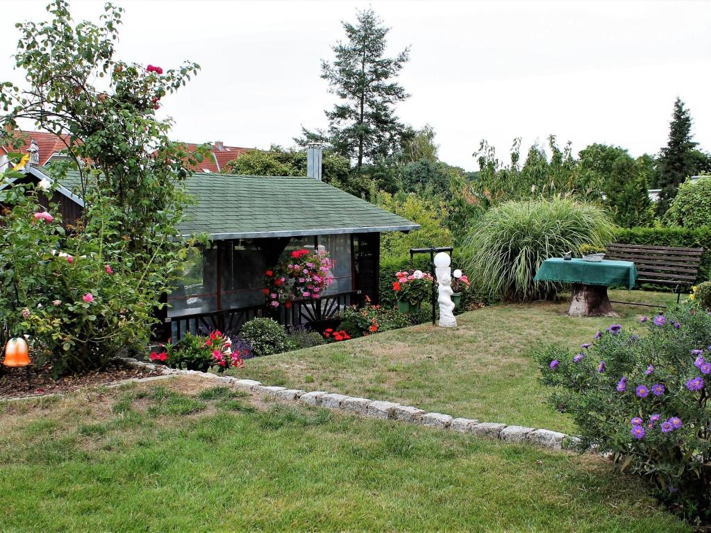 ProsekenにあるFerienwohnung Jutta in der Nähe der Ostseeの花が咲く庭とベンチのある家