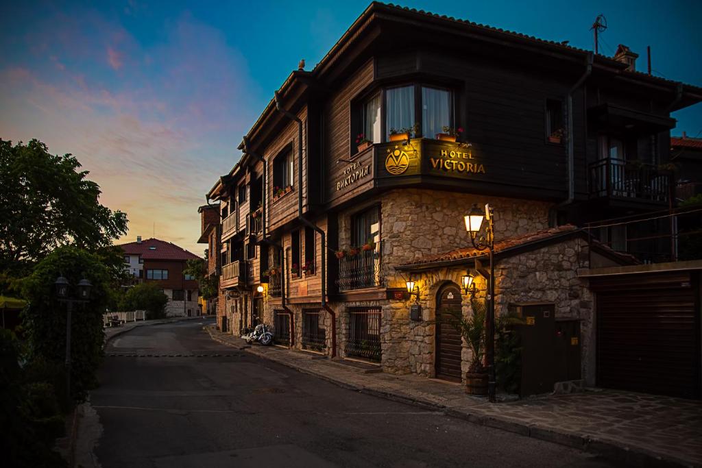 un edificio con un cartel en una calle en Victoria Hotel Nessebar, en Nesebar