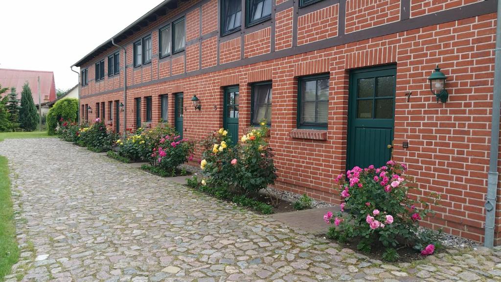 a brick building with flowers in front of it at Landferienhof "Müritzufer" in Ludorf