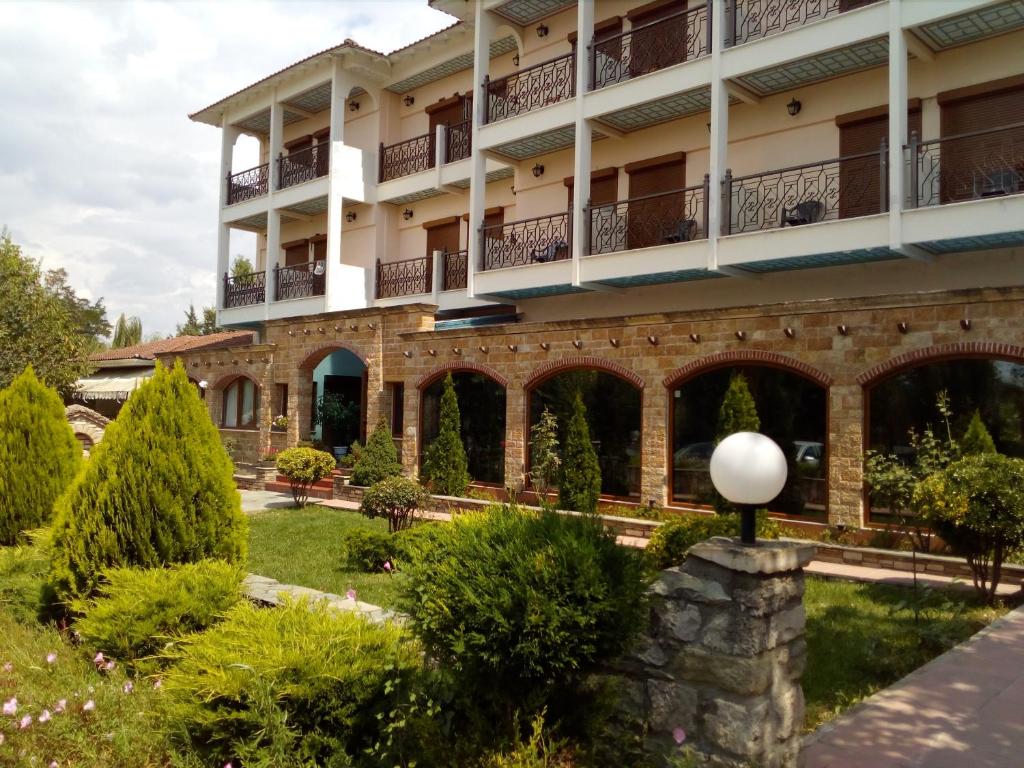 a large building with a garden in front of it at Nefeli Hotel in Kozani