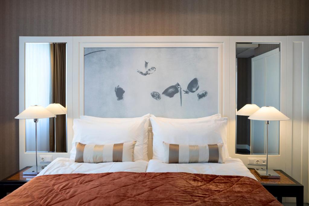 a bed with a white bedspread and pillows on top of it at The Harmonie Vienna, BW Premier Collection in Vienna
