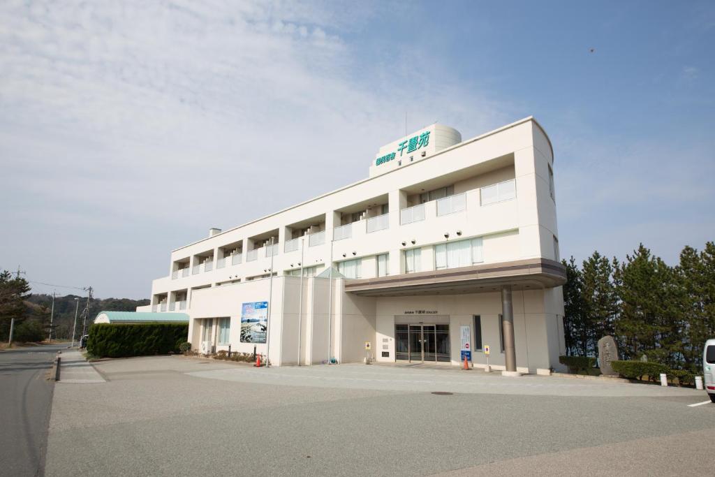 un gran edificio blanco con un cartel. en Senjoen, en Shimokō