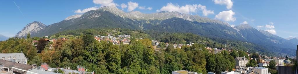 eine Stadt auf einem Hügel mit einem Berg im Hintergrund in der Unterkunft penthouse innsbruck in Innsbruck