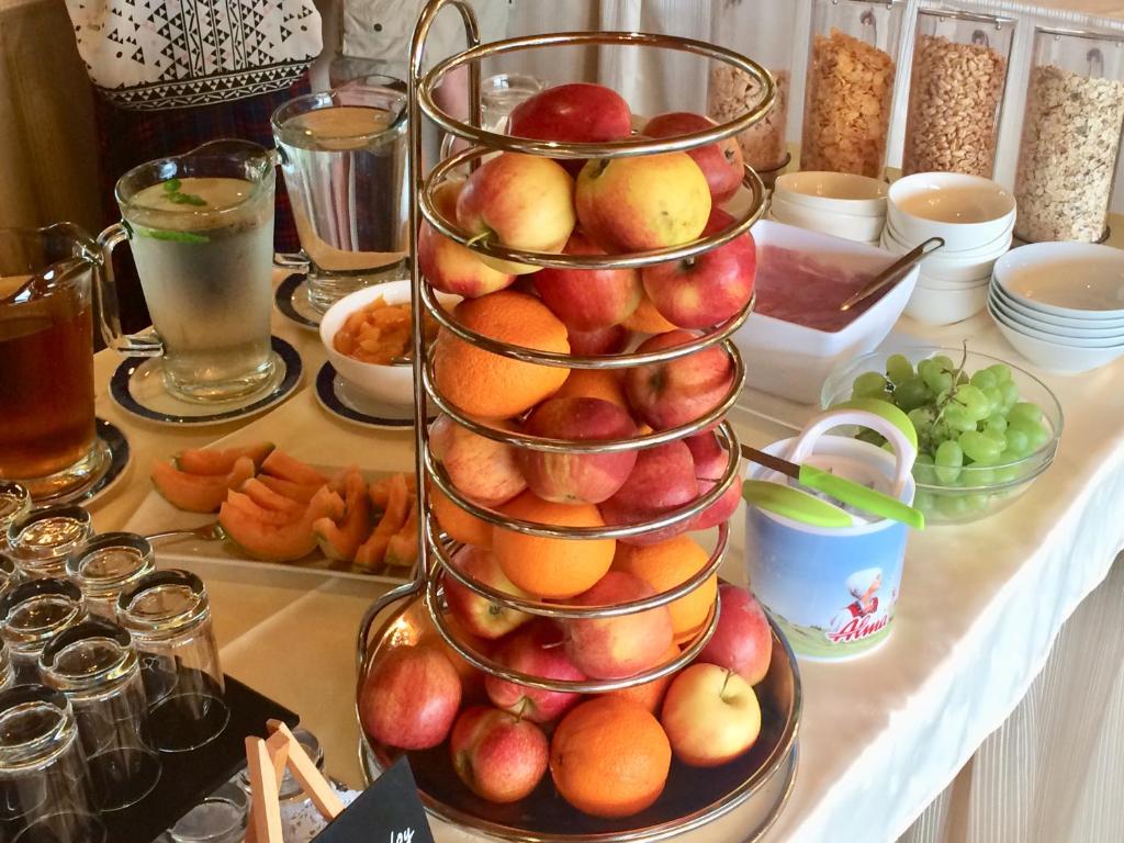 a tiered tower of apples and oranges on a table at Hotel Garni Wurzer in Velden am Wörthersee