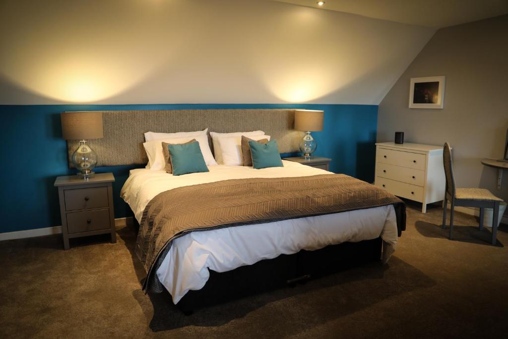 um quarto com uma cama grande e paredes azuis em Bay and Bridge em Dunfermline