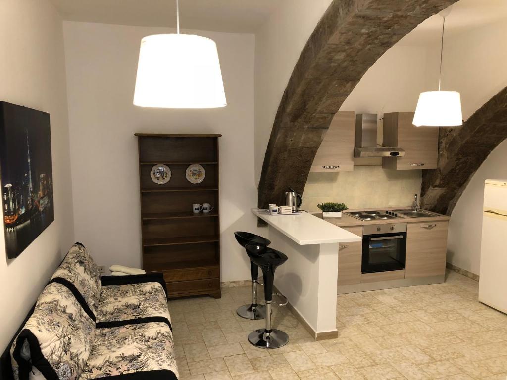 eine Küche mit einem Sofa und einem Tisch in einem Zimmer in der Unterkunft Gli Archi in Montefiascone