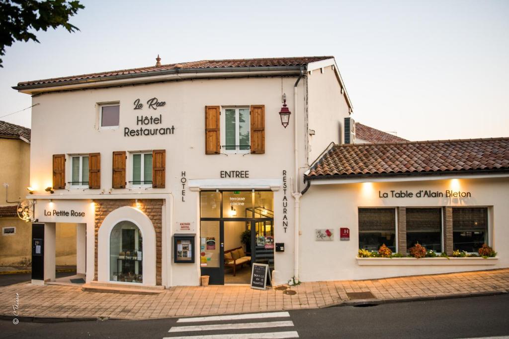 a white building on a street with a crosswalk at La Rose in Juliénas