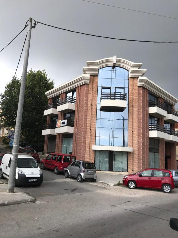 un gran edificio con coches estacionados en un estacionamiento en Port of Corfu Apartment en Corfú
