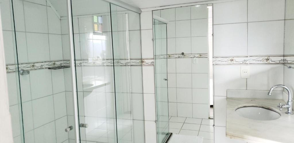 a bathroom with a shower with a sink and a toilet at Pousada na Montanha in Domingos Martins