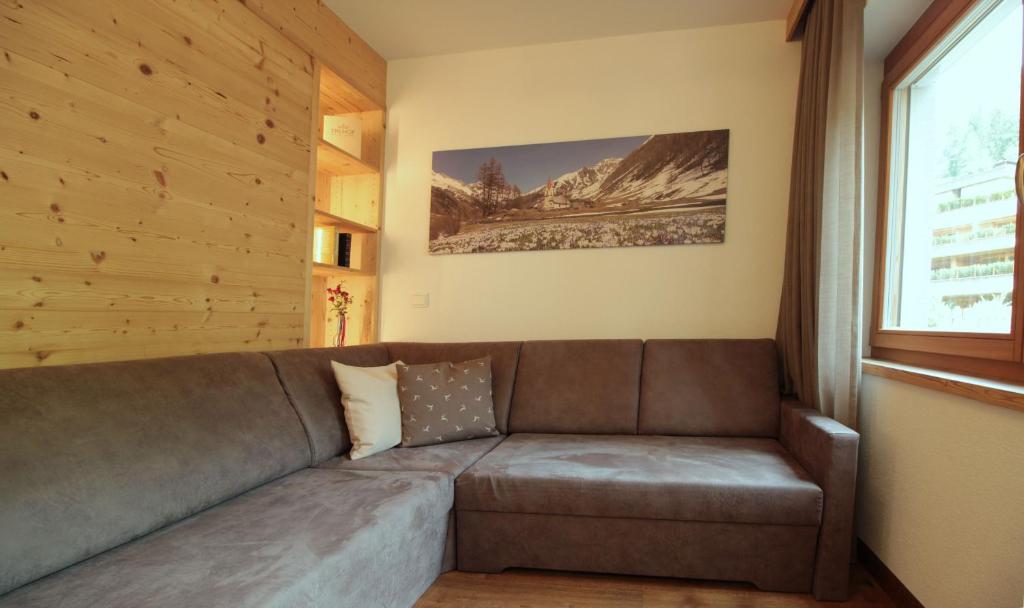 a brown couch in a room with a window at Appartement Hotel Erlhof Deluxe in Lutago