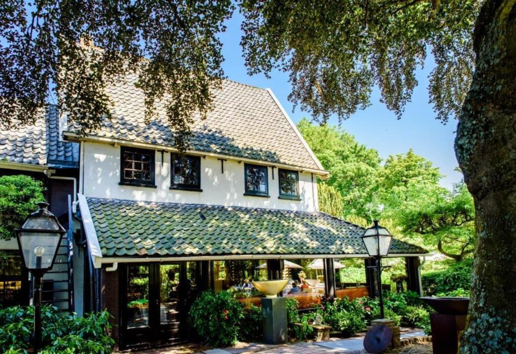 una casa con un conservatorio con gente en ella en Villa Beukenhof en Oegstgeest