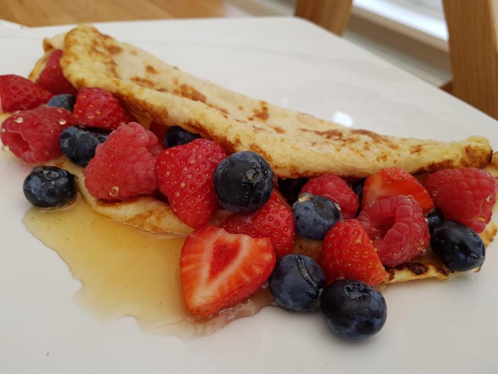 a plate with a waffle with fruit on it at Willow House B&B in West Wittering
