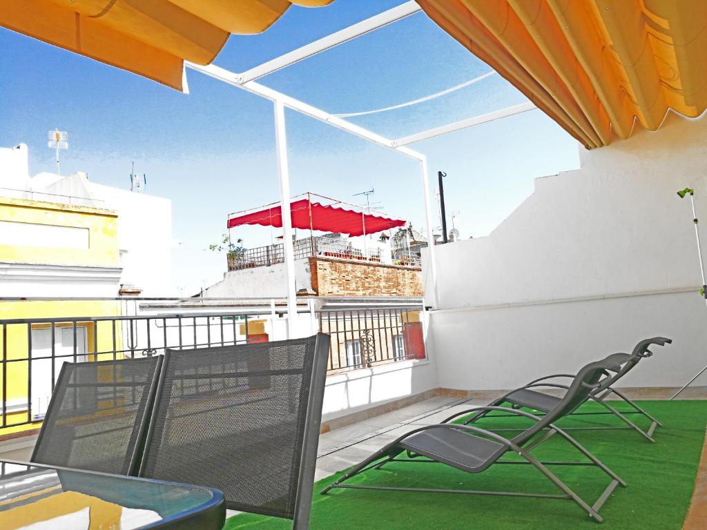 a balcony with a chair and a red umbrella at Hostel A2C in Seville